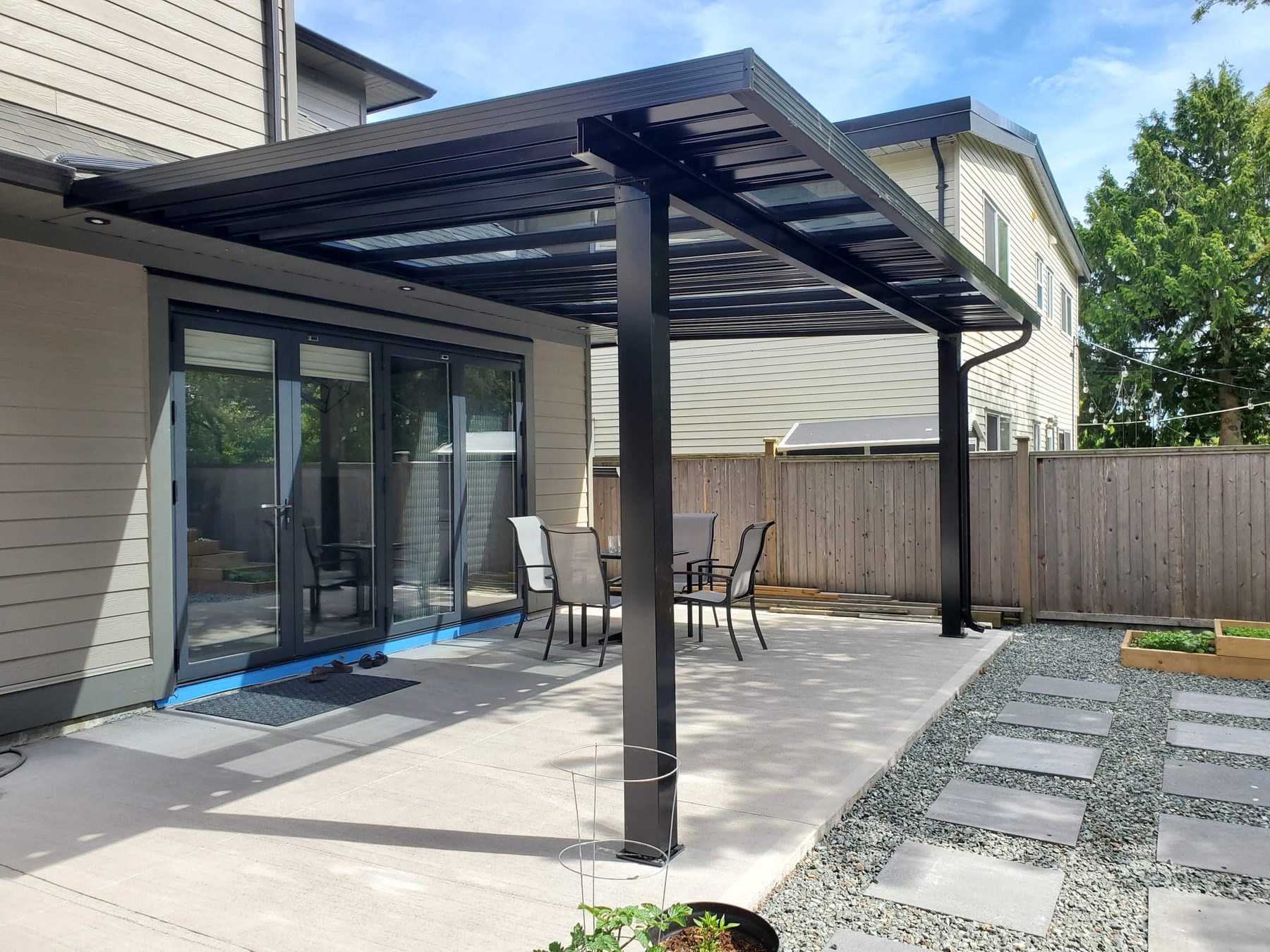 Custom black aluminum pergola over a backyard patio